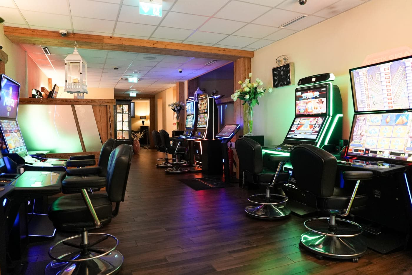 Reihe aktueller Geldspielgeräte mit Sesseln davor